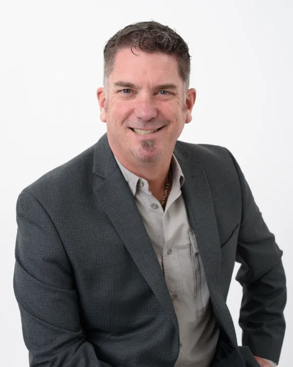 Greg Elwin, principal of 4th Quarter Properties, in a grey blazer